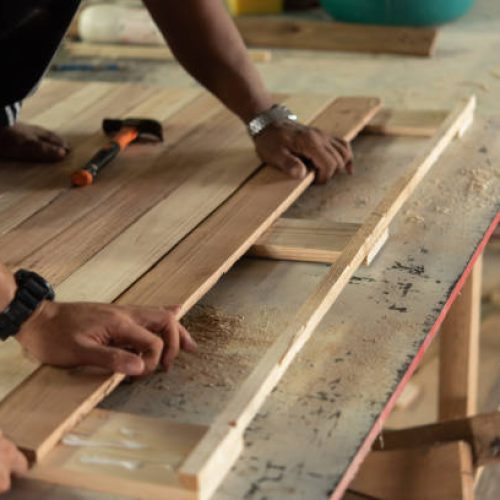 Asian carpenter build furniture or products from slat and timber wood from natural hardwood in warehouse or sawmill at wood factory for a construction or sale