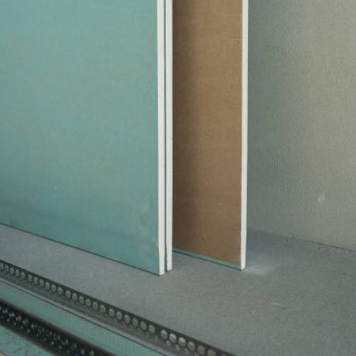 Green waterproof drywall or greenboard. Paper faced gypsum board, moisture proof plasterboard building material. Panel used in construction of interior walls and ceilings.