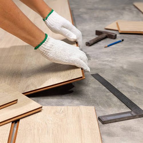Worker Installing Interlocking laminate floor, home renovation.