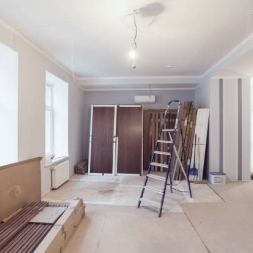 Interior of apartment  during construction, remodeling, renovation, extension, restoration and reconstruction - ladder and construction materials in the room.